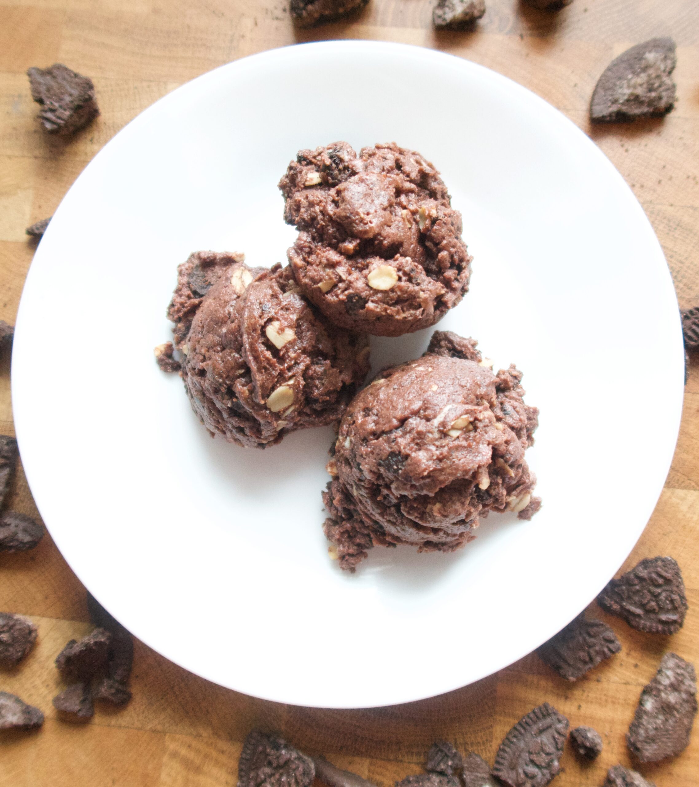 3 oreo brownie bites on a white plate surrounded by oreo crumbs