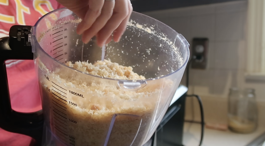 food processor bowl with pork rinds and cheese in it