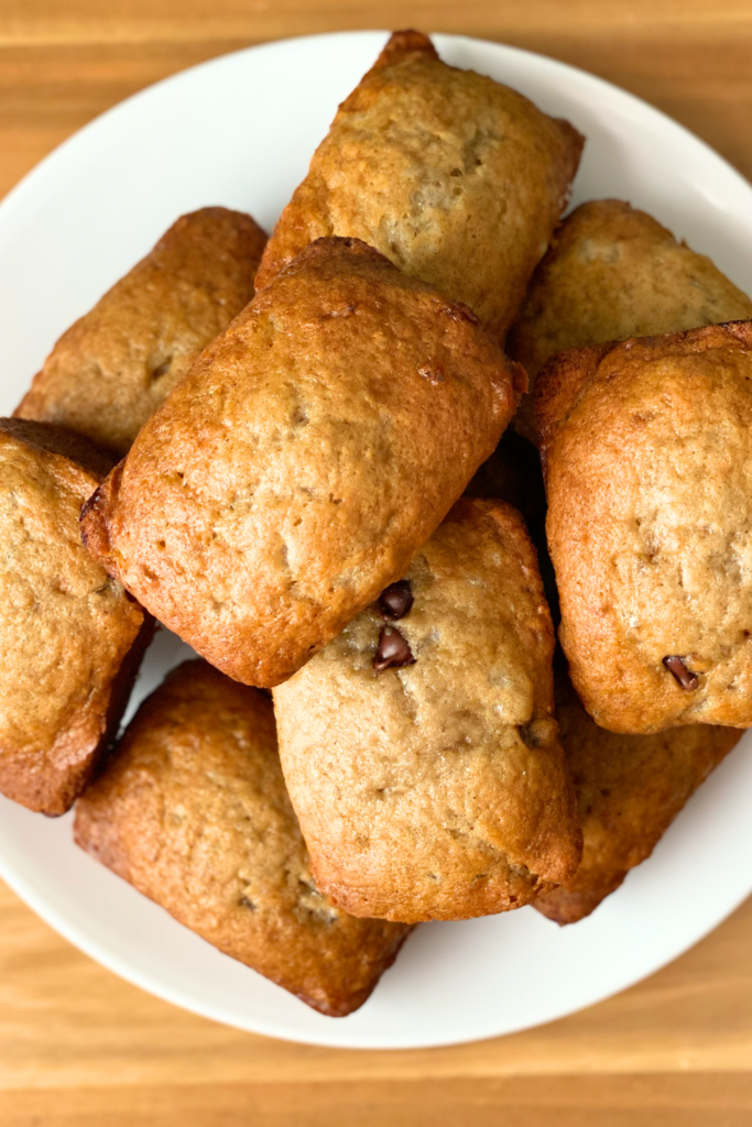 small loaves of banana bread stacked on a white plate
