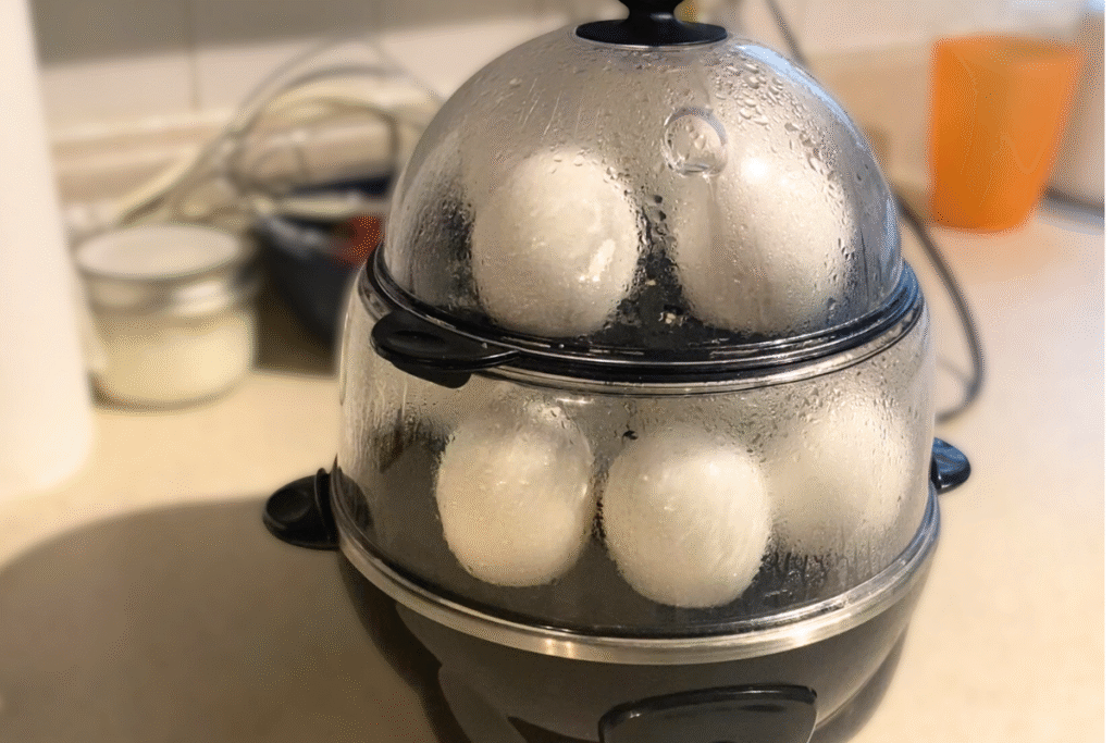 dash egg cooker on the counter filled with eggs