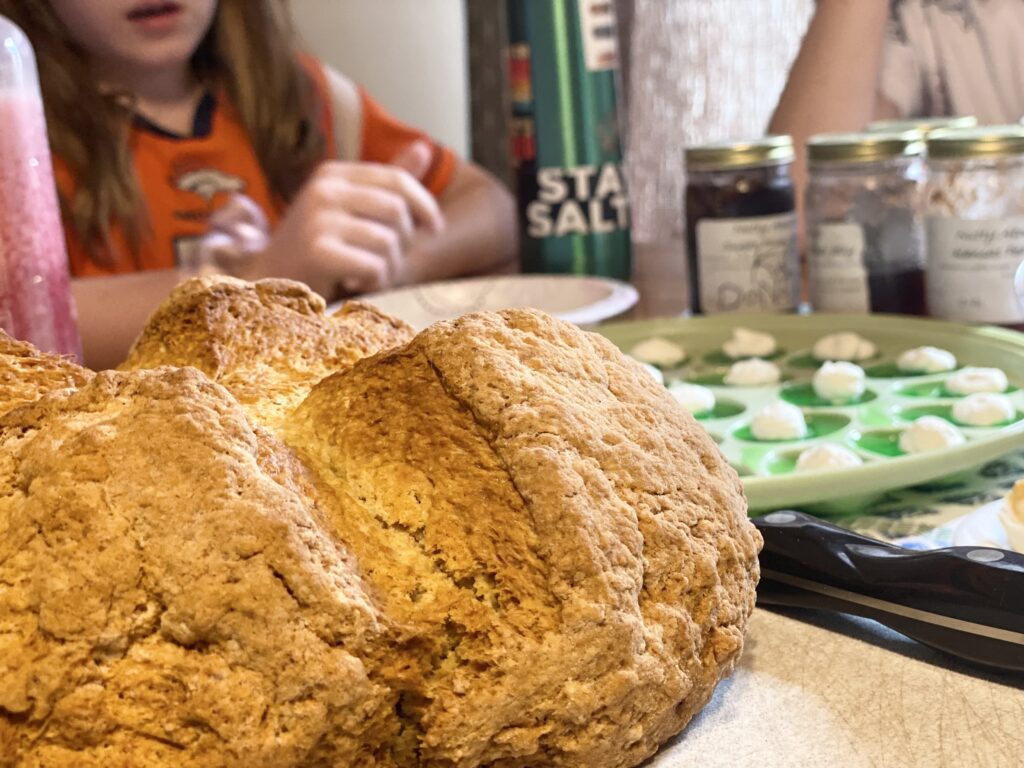 close up photo of irish soda bread with green jello eggs in the background.